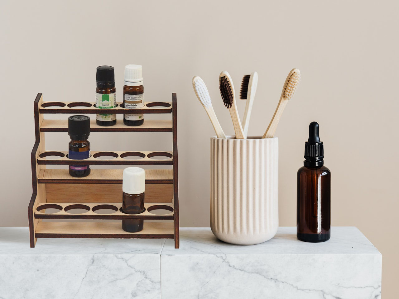 rangement à huiles essentielles en bois sur une étagère de salle de bain à côté d'autres produits.
